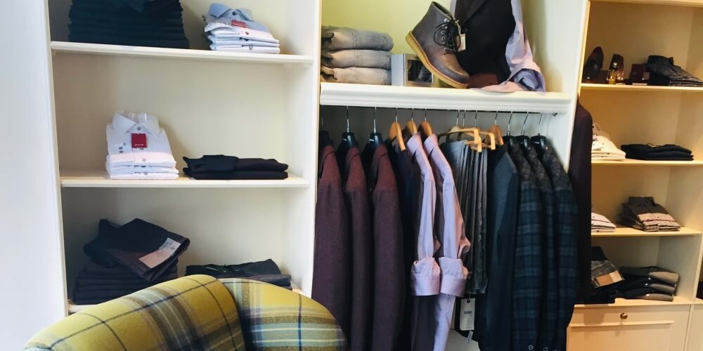 Folded shirts and tweed jackets on the menswear side of Leaf Clothing