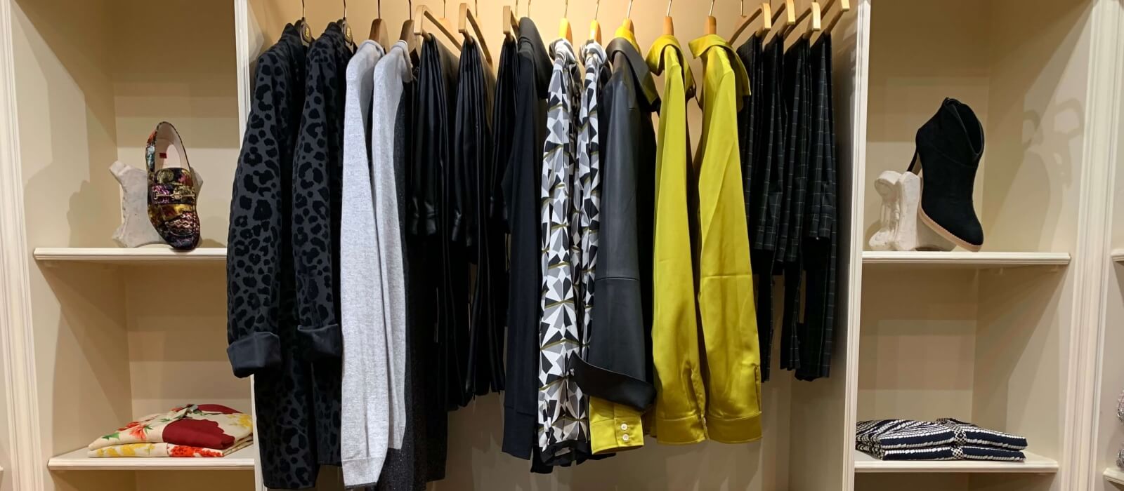 The womenswear rail at Leaf Clothing, leopard print, monochrome geometric and yellow satin shirting hung together